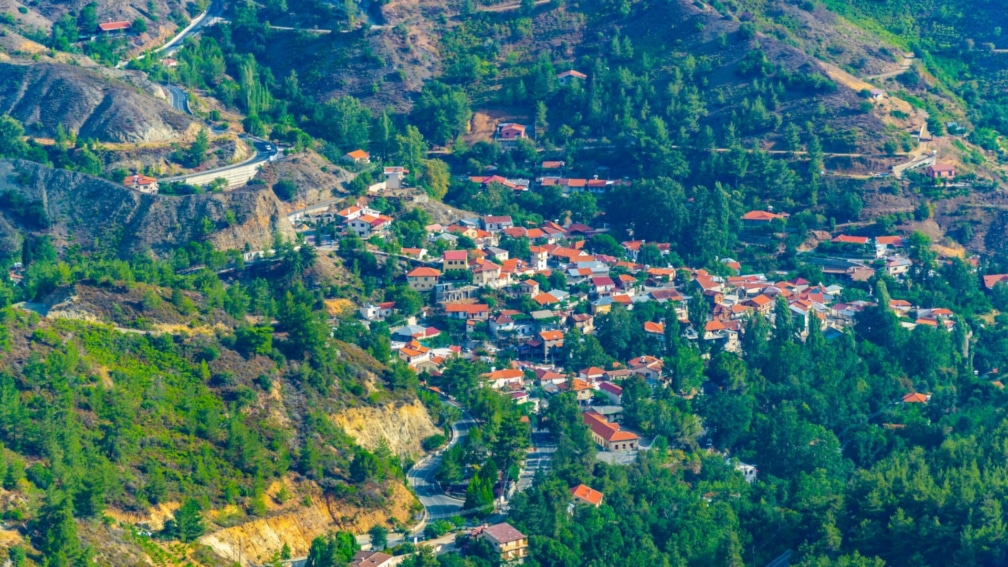 A high angle shot of the mountains with some apartment buildings in the middle.