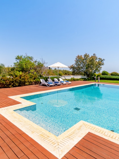 An outdoor swimming pool in the floor, with an outdoor shower next to it