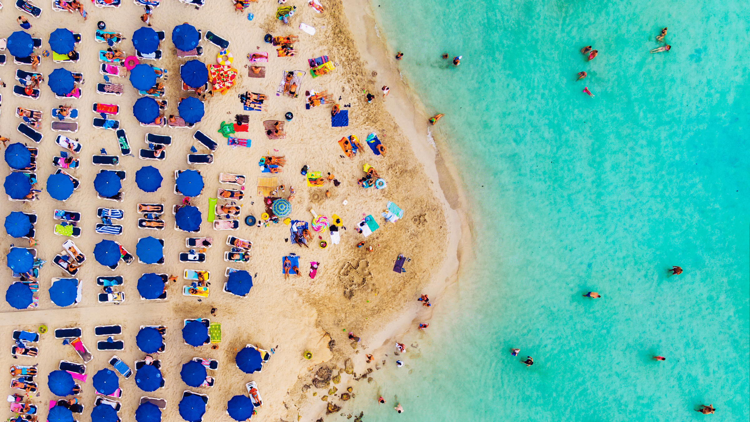 birds eye image of a busy beach and the sea