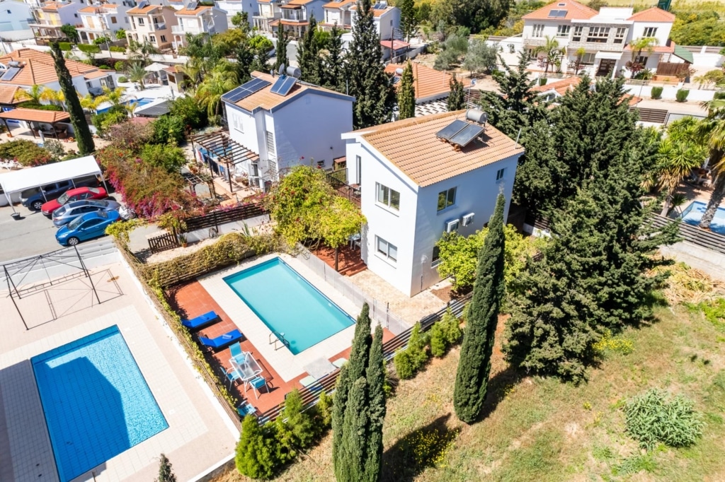 a high angle of some villas, with pools outside and a garden